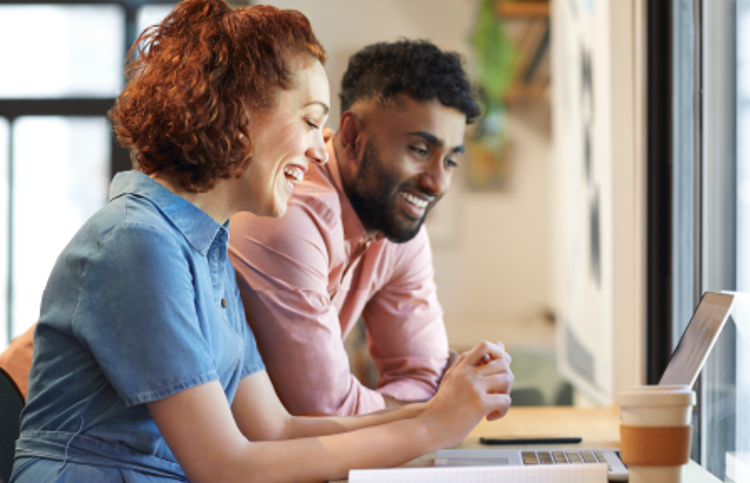 Two people looking at a computer collaborating