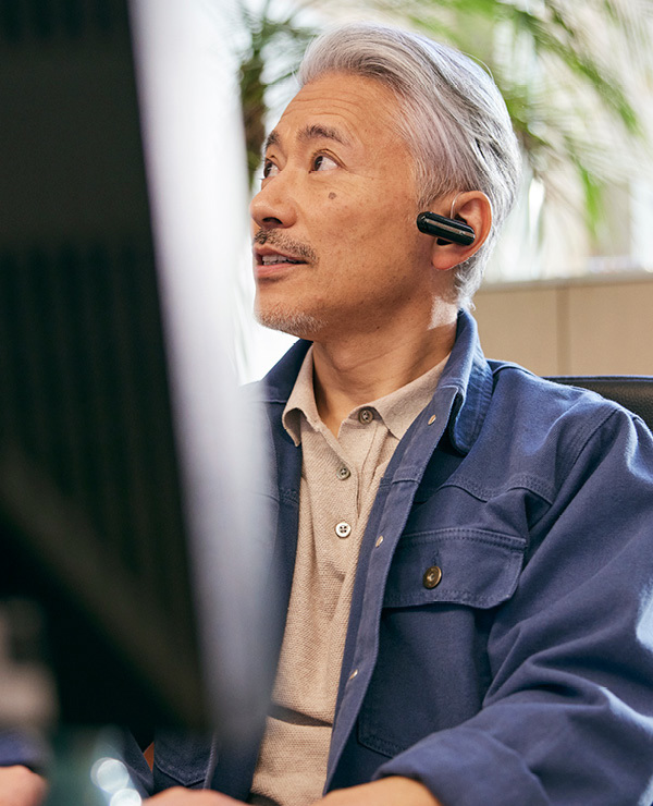 Man with Bluetooth headset in typing on keyboard looking up