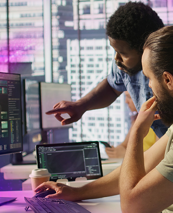 Two individuals looking at monitors