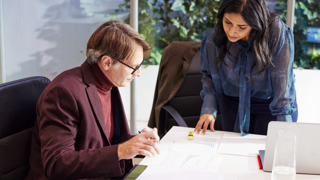 Photo of two people looking at something on a desk