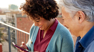 Two people looking at phone smiling