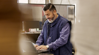 Man working on laptop at standing desk