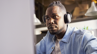 Man with headphones on looking at screen