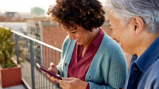 Two people looking at a cellphone and smiling