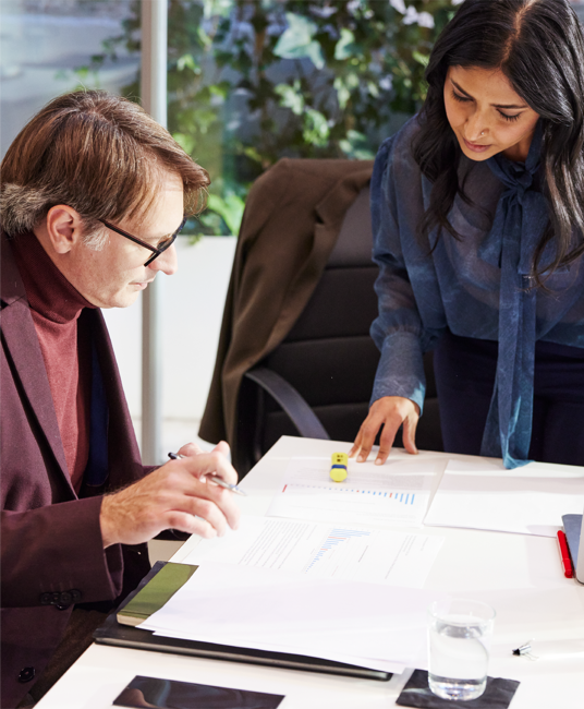 Two people looking at documents on a table