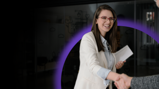 Woman with document in one hand shaking other hand with man in early talent career