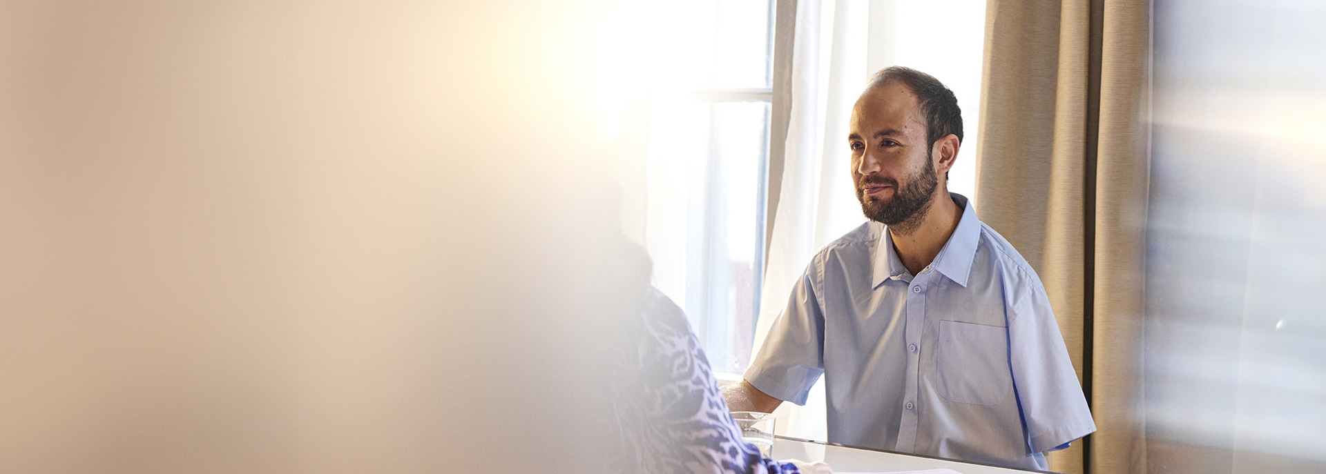 Man with one arm sitting as desk interviewing job candidate