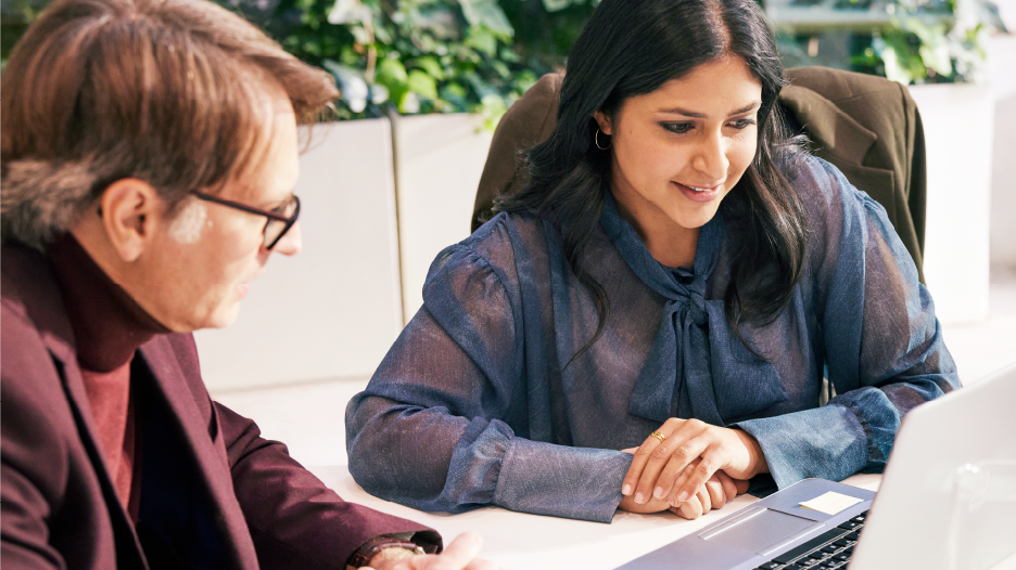 Two people looking at a computer collaborating