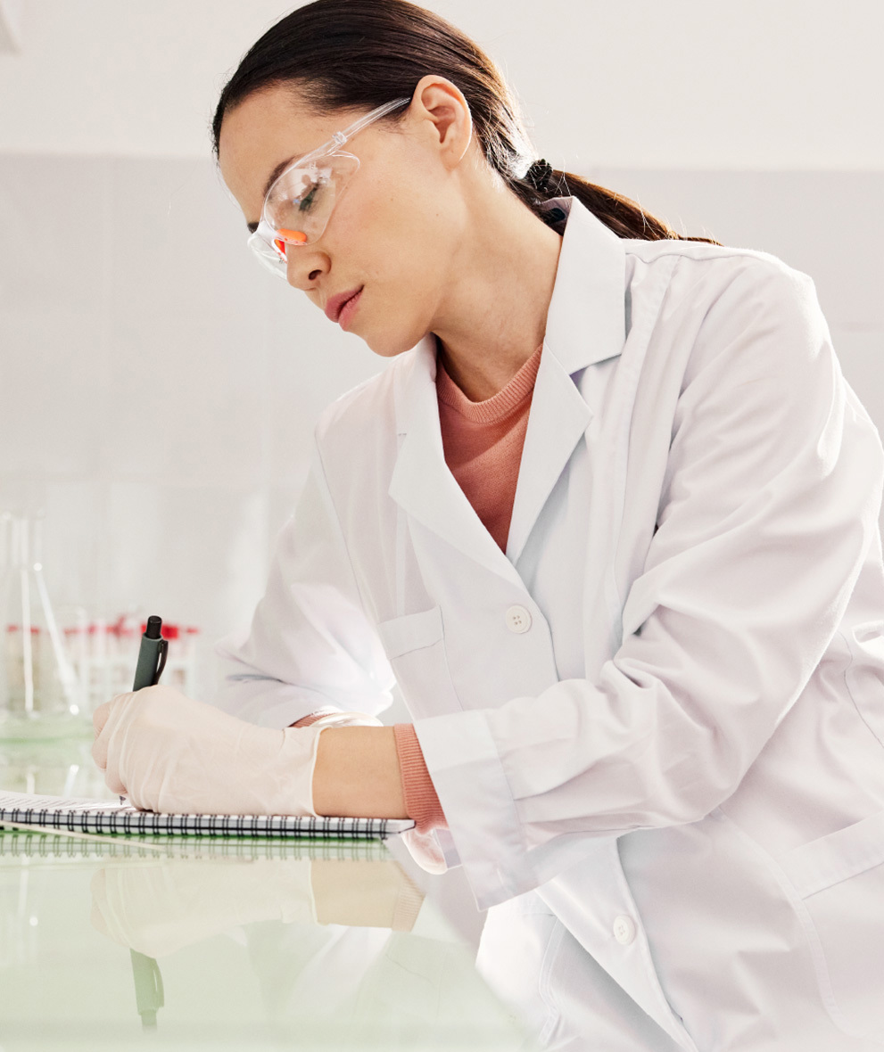 Photo of a scientist writing research in a notebook