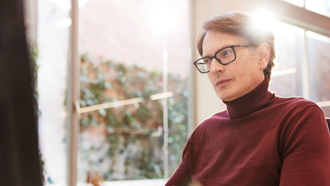 Individual wearing glasses and turtle neck