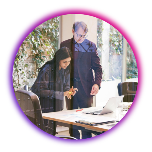 Two people at a desk in a colored circle