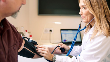 Doctor taking patient's blood pressure