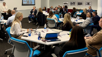 group of people sat around tables at a conference