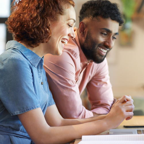 two professionals sat in front of laptop