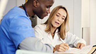 A doctor and nurse looking at documents