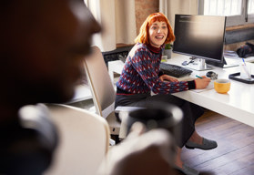 A woman working at a computer smiling 