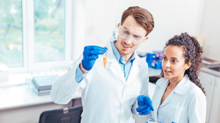 Two scientist in a lab looking at test tube