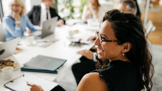 Woman laughing at conference table 